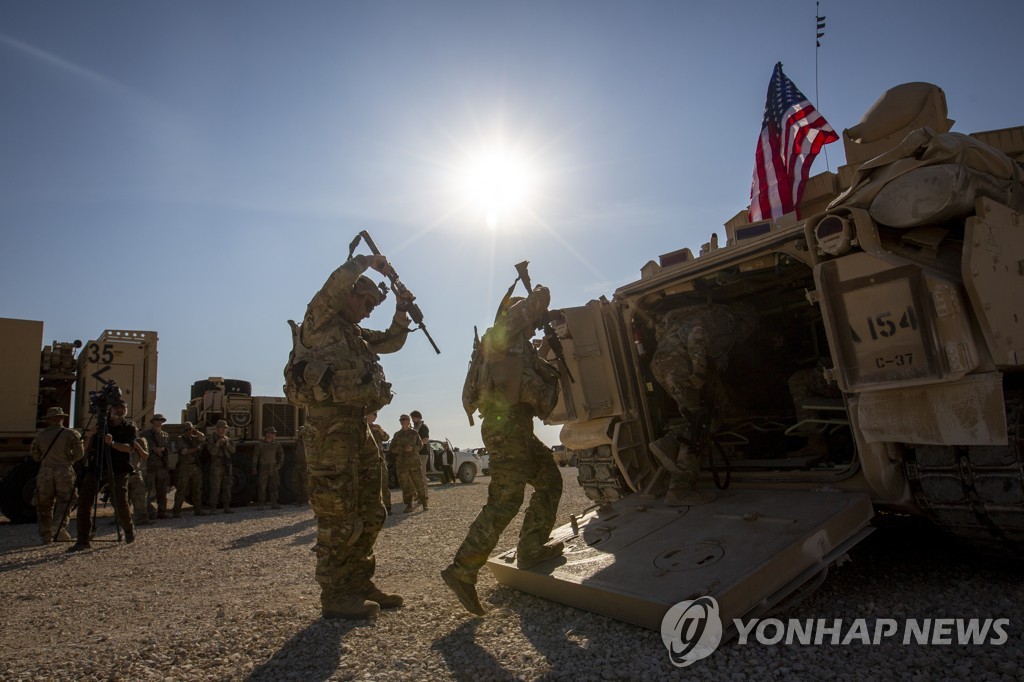 시리아 동북부에서 미군 장병이 브래들리 장갑차에 올라타고 있다.
