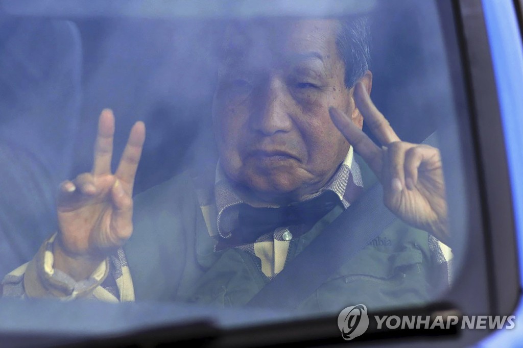 재심 결정에 손가락으로 V자 표시한 하카마다 씨