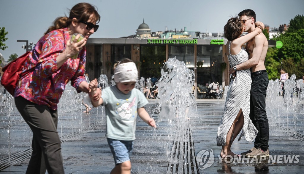 (AFP 모스크바=연합뉴스) 봄철 이상 고온 현상이 나타난 17일 야외 분수광장을 찾은 모스크바 시민들