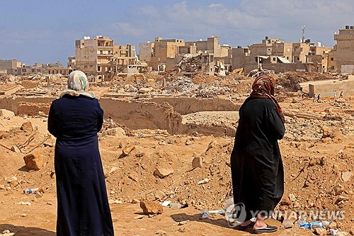 무너진 집터에서 실종된 가족들을 찾고 있는 여성들