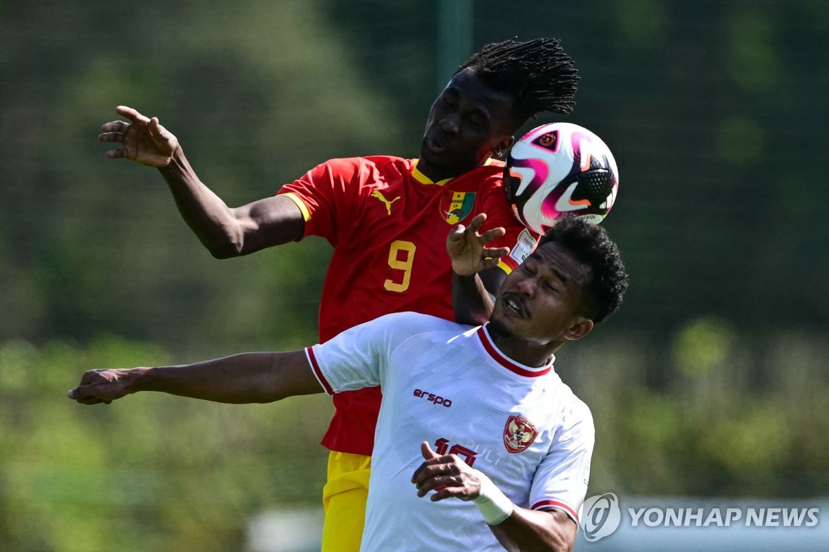 In this AFP photo, Bagas Kaffa of Indonesia (R) battles Momo Fanye Toure of Guinea for the ball during the teams' Olympic qualifying playoff match at INF Clairefontaine in Clairefontaine-en-Yvelines, France, on May 9, 2024. (Yonhap)