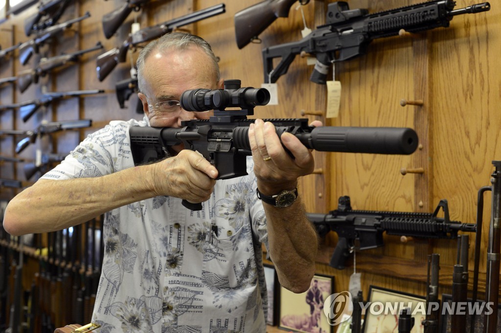 돌격소총 AR-15로 조준시범을 보이는 미국 캘리포니아주(州) 총기판매상. [EPA=연합뉴스 자료사진]