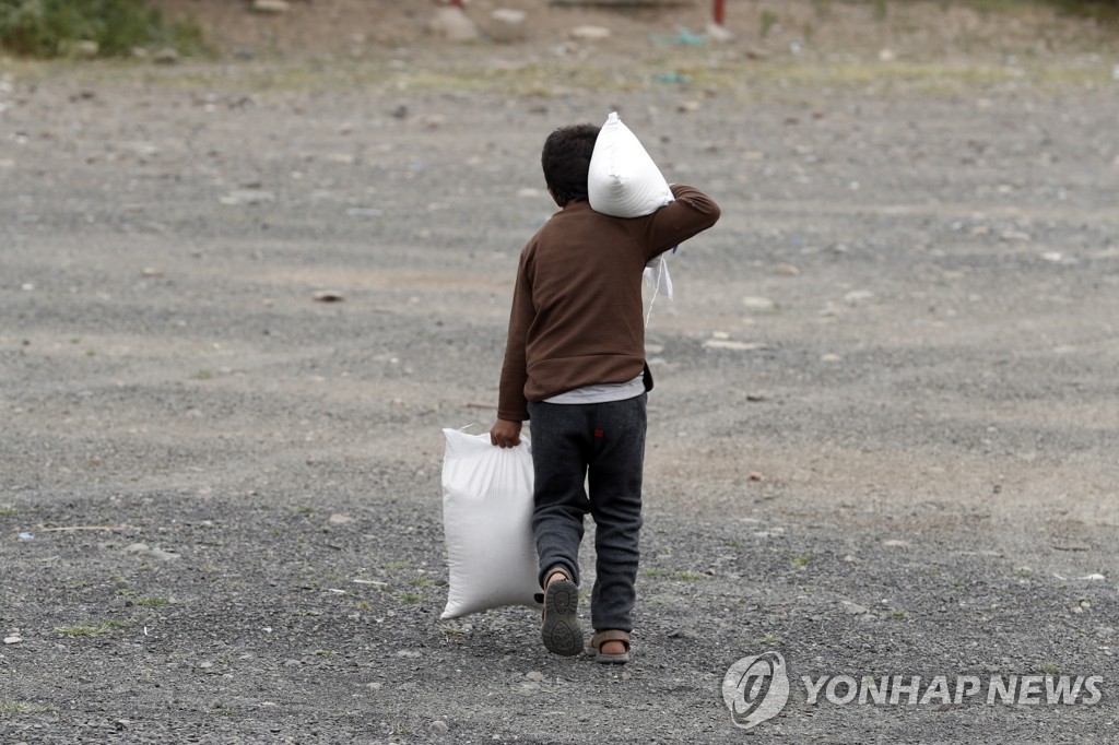 구호단체로부터 식량 배급을 받아 가는 예멘의 어린이