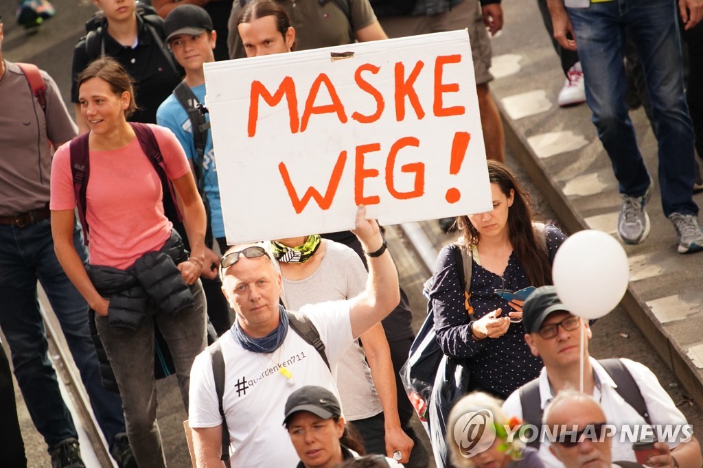 8월 29일 독일 베를린에서 열린 신종 코로나바이러스 감염증(코로나19) 관련 규제 반대 시위에서 한 참가자가 '마스크는 가라'라고 적힌 종이를 들고 있다. [EPA=연합뉴스 자료사진]