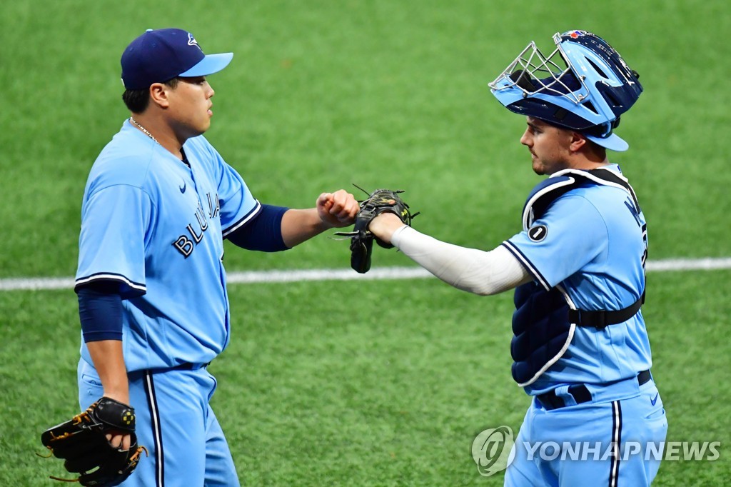 In this Getty Images file photo from Aug. 22, 2020, Ryu Hyun-jin of the Toronto Blue Jays (L) bumps fists with his catcher Reese McGuire before a Major League Baseball regular season game against the Tampa Bay Rays at Tropicana Field in St. Petersburg, Florida. (Yonhap)