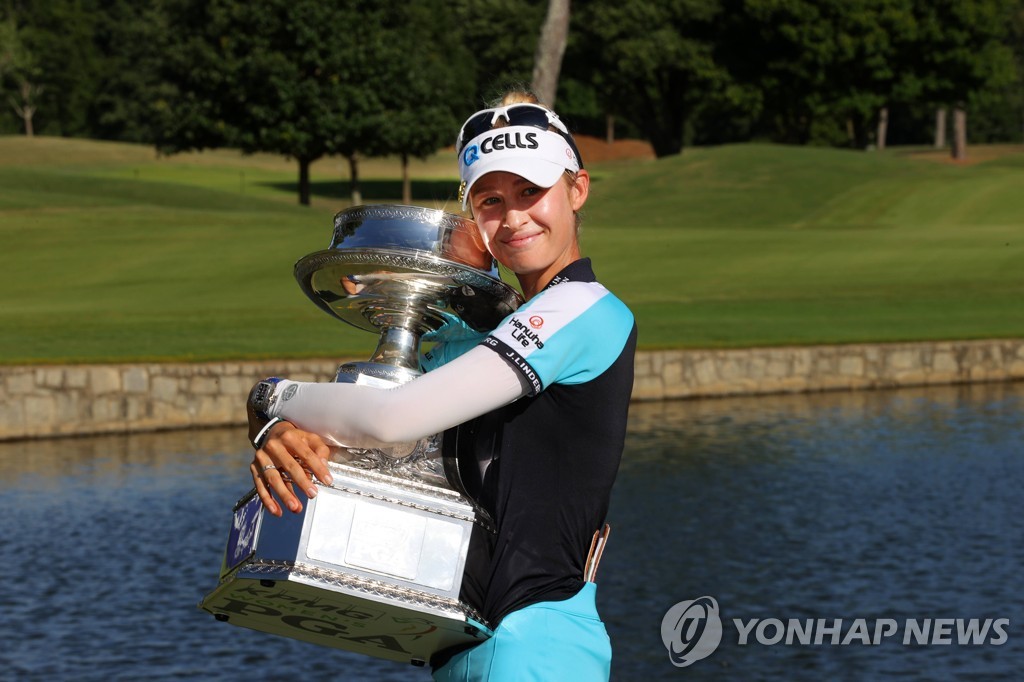 In this Getty Images photo, Nelly Korda of the United States poses with the champion's trophy after winning the KPMG Women's PGA Championship at Atlanta Athletic Club in Johns Creek, Georgia, on June 27, 2021. (Yonhap)