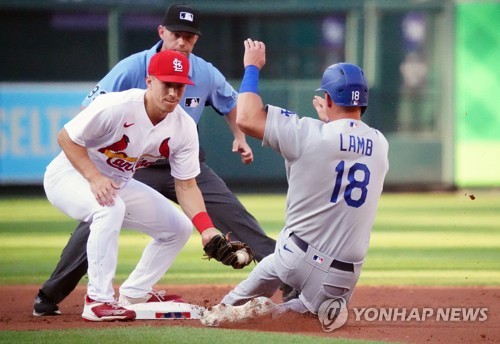 In this UPI file photo from July 14, 2022, St. Louis Cardinals shortstop Tommy Edman (L) puts the tag on Jake Lamb of Los Angeles Dodgers at second base in a steal attempt during the top of the second inning of a Major League Baseball regular season game at Busch Stadium in St. Louis. (Yonhap)