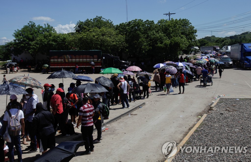 26일(현지시간) 온두라스 접종센터 앞에 줄 서 있는 니카라과인들