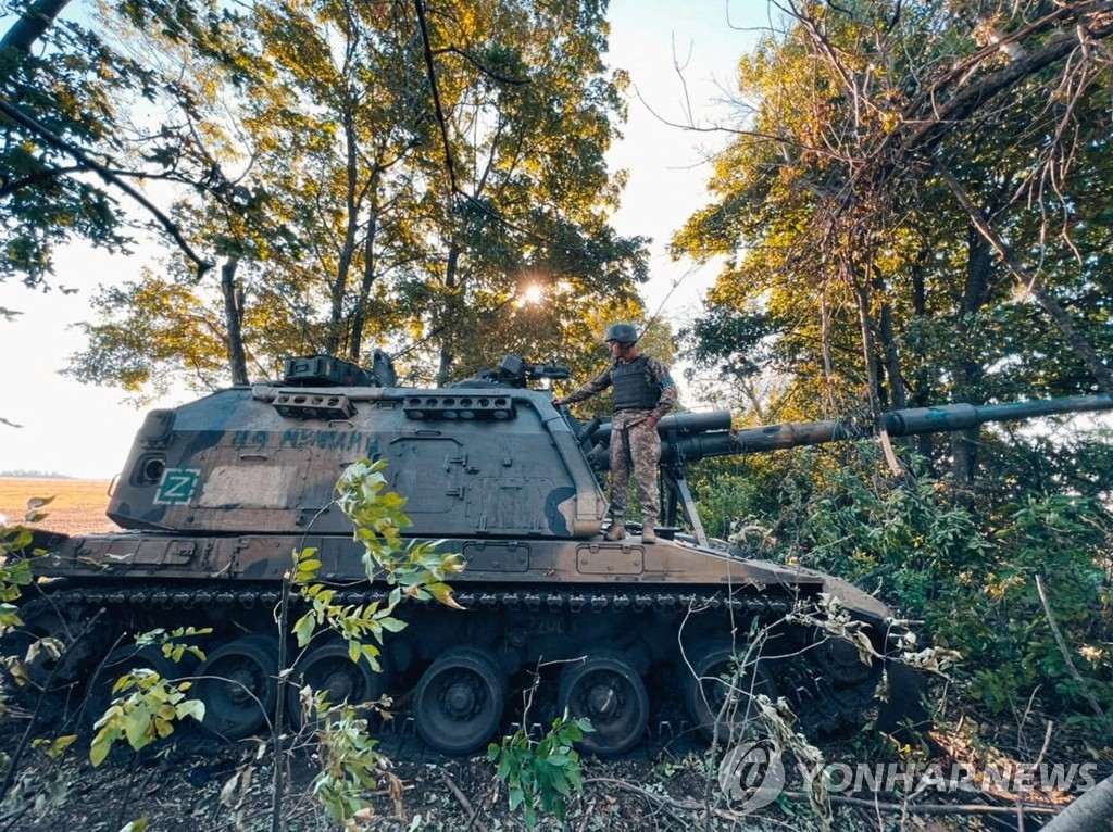 하르키우 지역에서 노획된 러시아군 2S19 자주포를 살피는 우크라이나군 병사
