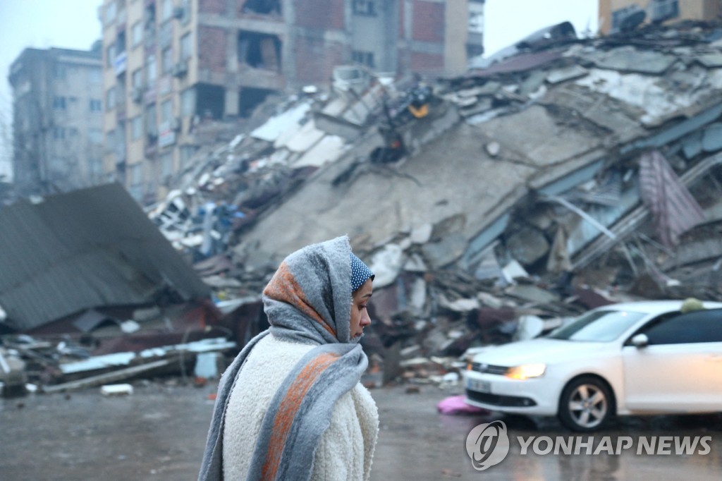튀르키예 카흐라만마라슈에서 무너진 건물 앞의 여성