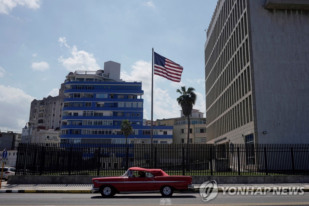 쿠바 아바나의 미 대사관 건물 앞을 달리는 자동차