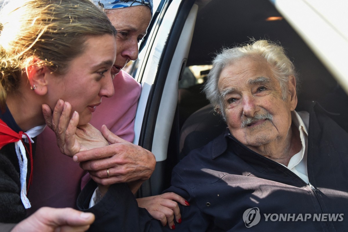 24일(현지시간) 대선 투표 후 주민들의 인사를 받는 우루과이 무히카 전 대통령