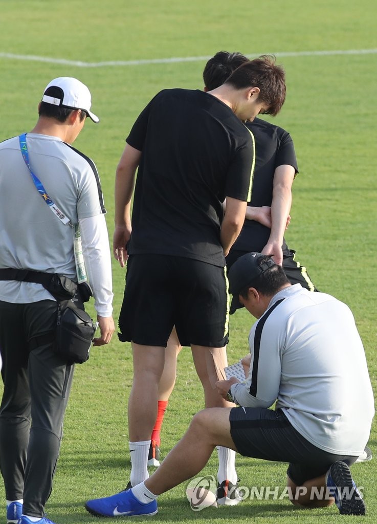 In this file photo taken on Jan. 13, 2019, South Korea national football team midfielder Ki Sung-yueng (C) receives treatment from medical staff ahead of training in Abu Dhabi, the United Arab Emirates. (Yonhap)