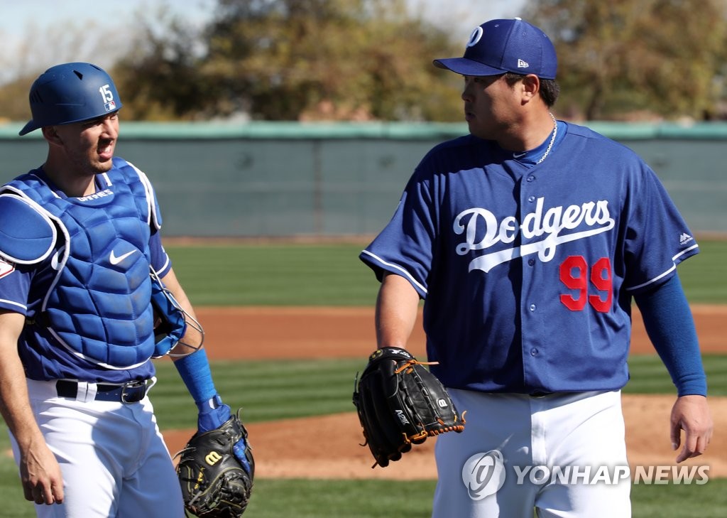 Ryu Hyun-jin of the Los Angeles Dodgers (R) speaks with his catcher Austin Barnes after throwing his first live batting practice of spring training at Camelback Ranch in Glendale, Arizona, on Feb. 19, 2019. (Yonhap)
