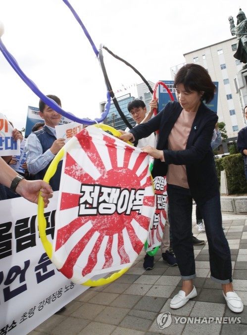 韓国南部・釜山の市民団体が東京五輪での旭日旗使用に反対するパフォーマンスを行った＝（聯合ニュース）