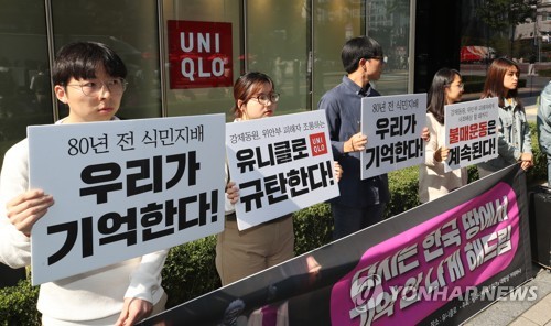 ソウル・鍾路のユニクロの店舗前で、ユニクロを非難する大学生グループ＝２１日、ソウル（聯合ニュース）