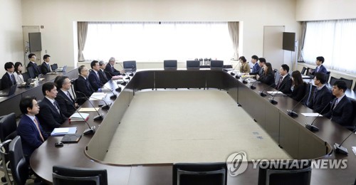 会議室に座った韓国側代表団（右）と日本側代表団＝１６日、東京（共同通信＝聯合ニュース）