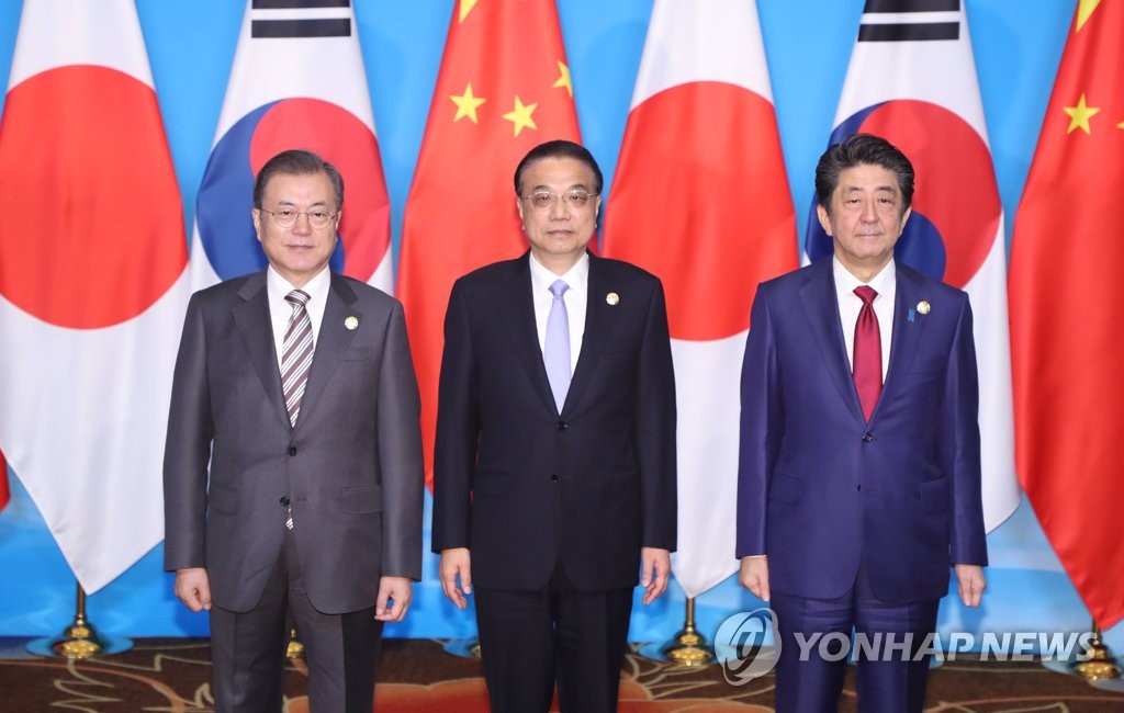 会談前、記念撮影する（左から）文大統領、李首相、安倍首相＝２４日、ソウル（聯合ニュース）