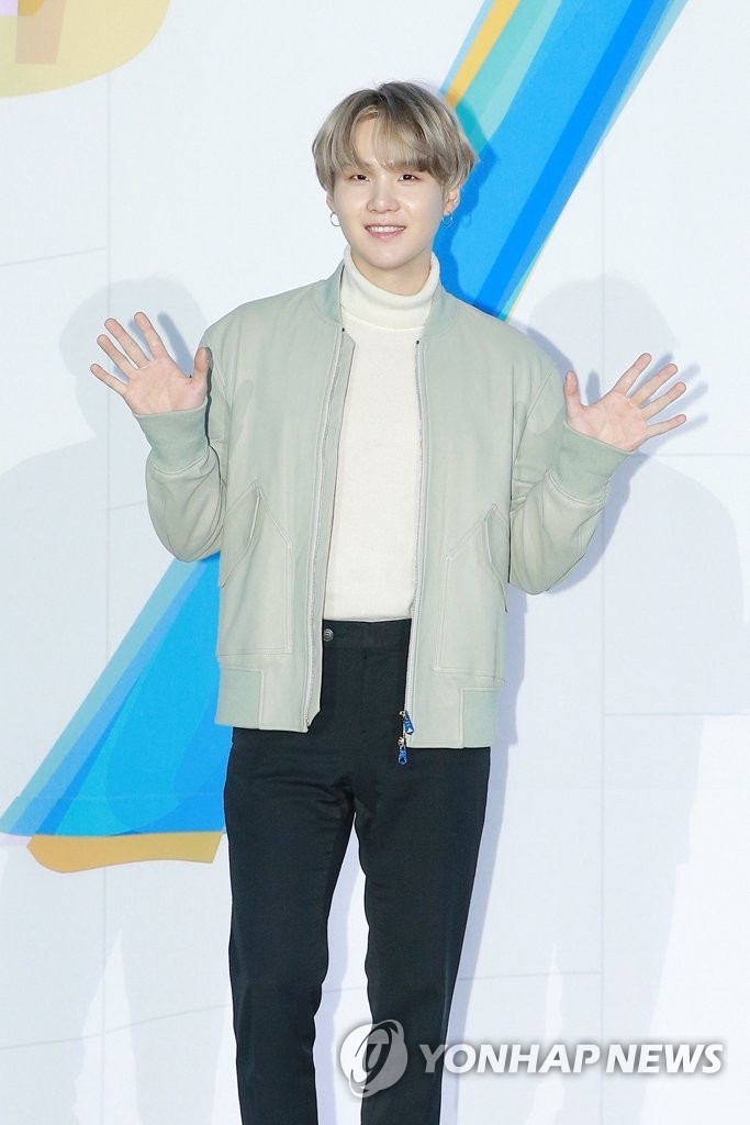 In this file photo provided by Big Hit Entertainment, BTS member Suga waves at reporters during a press conference held at COEX, southern Seoul, on Feb. 24, 2020. (Yonhap)