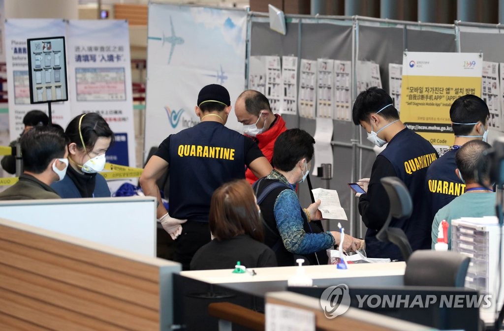 资料图片：3月9日，在仁川机场，来自日本的旅客在接受检疫。 韩联社
