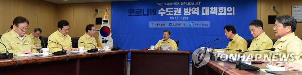 President Moon Jae-in (C) presides over a meeting on efforts to contain the COVID-19 outbreak at Seoul City Hall on March 16, 2020. (Yonhap)