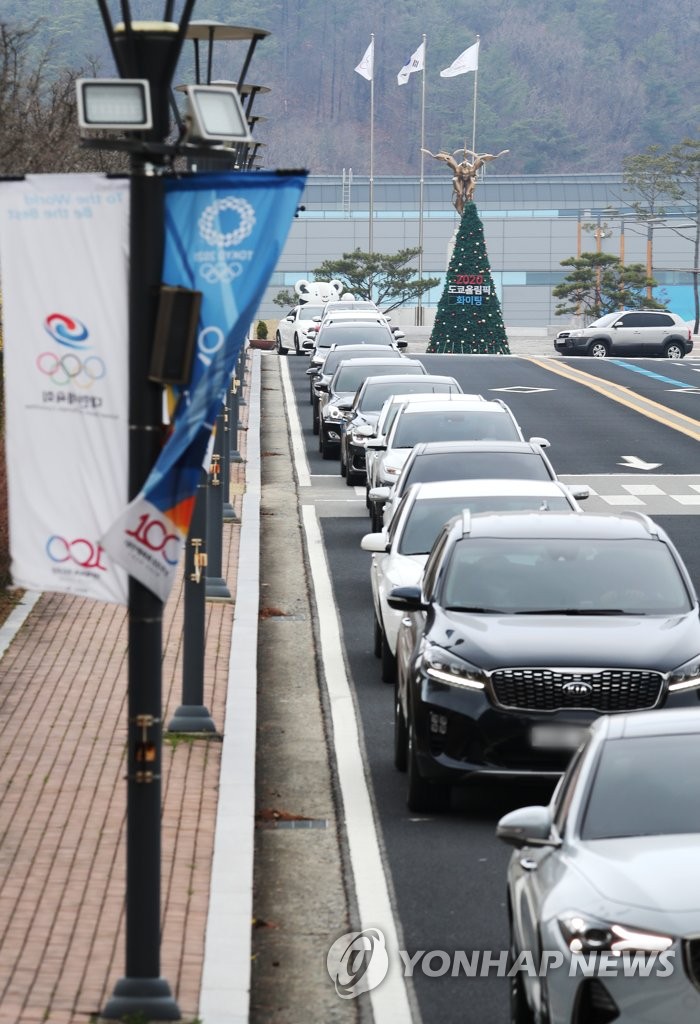 In this file photo from March 27, 2020, vehicles are lined up near the exit of the Jincheon National Training Center in Jincheon, 90 kilometers south of Seoul, as athletes and coaches move out of the facility following the postponement of the Tokyo Olympics. (Yonhap)