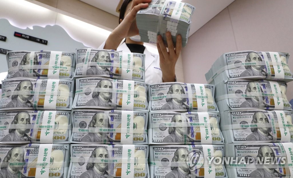 In the photo, taken March 31, 2020, a Bank of Korea (BOK) official is seen inspecting U.S. banknotes, set to be delivered to local banks as the first batch of U.S. dollar injections under the BOK's bilateral currency swap arrangement with the U.S. Fed. (Yonhap)