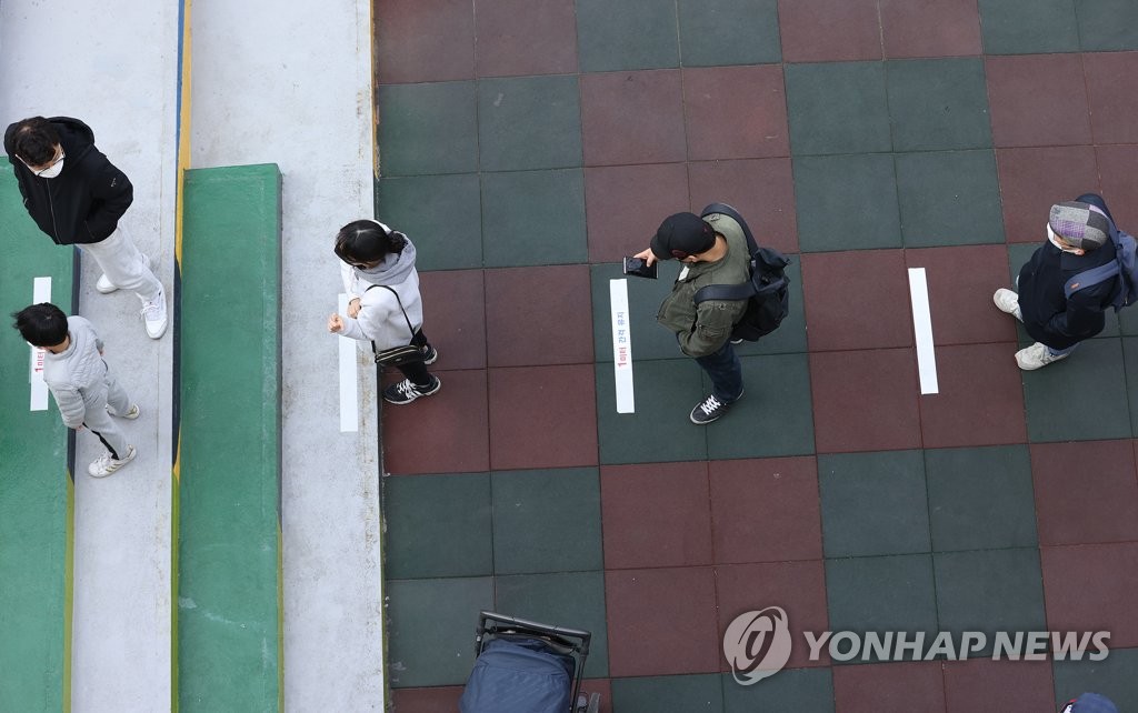 Voters stand 1 meter apart from each other as they wait to cast their ballots at a polling station in the eastern Seoul ward of Seongdong on April 10, 2020. (Yonhap)