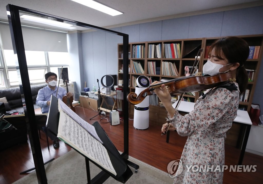 A student of Seoul National University's music school attends a lesson with her professor, separated by a transparent partition, on May 7, 2020, the second day of the implementation of "everyday life quarantine" measures against COVID-19. (Yonhap)