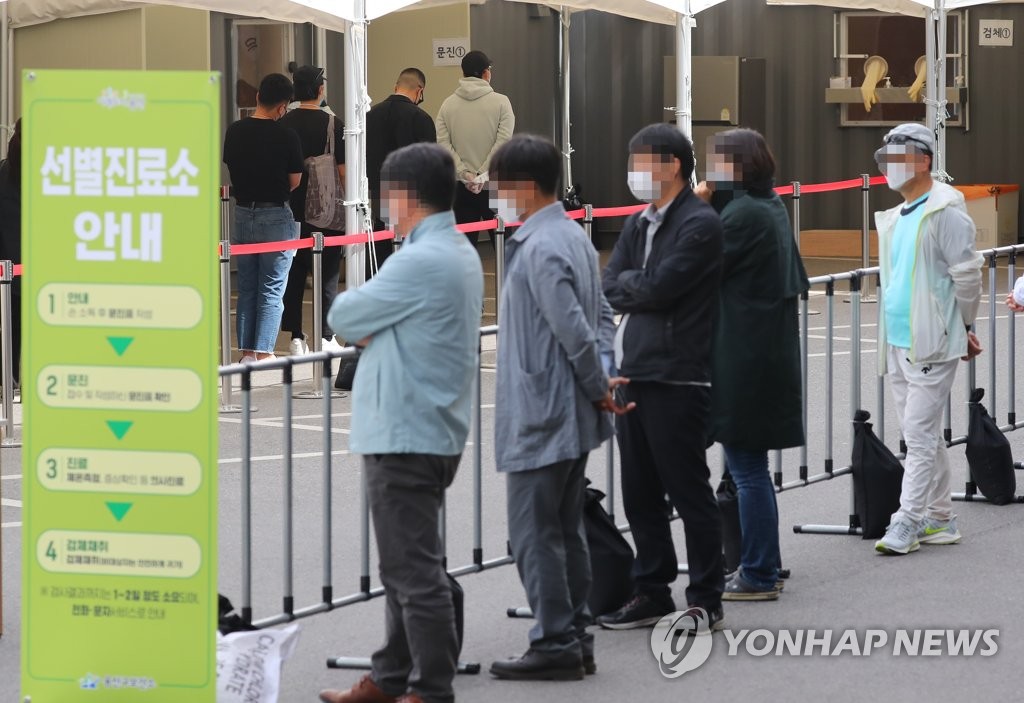 People wait to be checked for the coronavirus at a screening center in the central Seoul ward of Yongsan on May 14, 2020. (Yonhap)