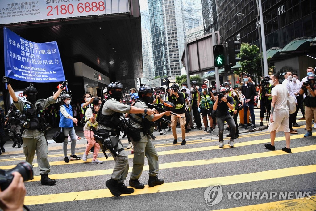 This AFP photo shows riot police in Hong Kong sending warnings to protesters opposing the national security bills to stop demonstrations, on May 27, 2020. (Yonhap)