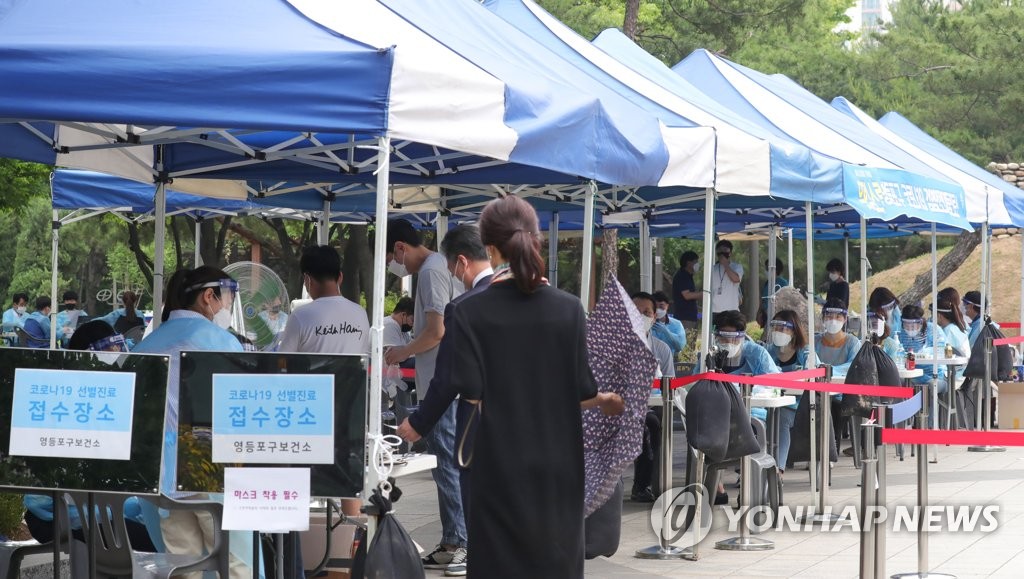 Citizens line up to receive tests for the new coronavirus at a "walk-through" testing site in the financial district of Yeouido in Seoul on May 31, 2020. (Yonhap)