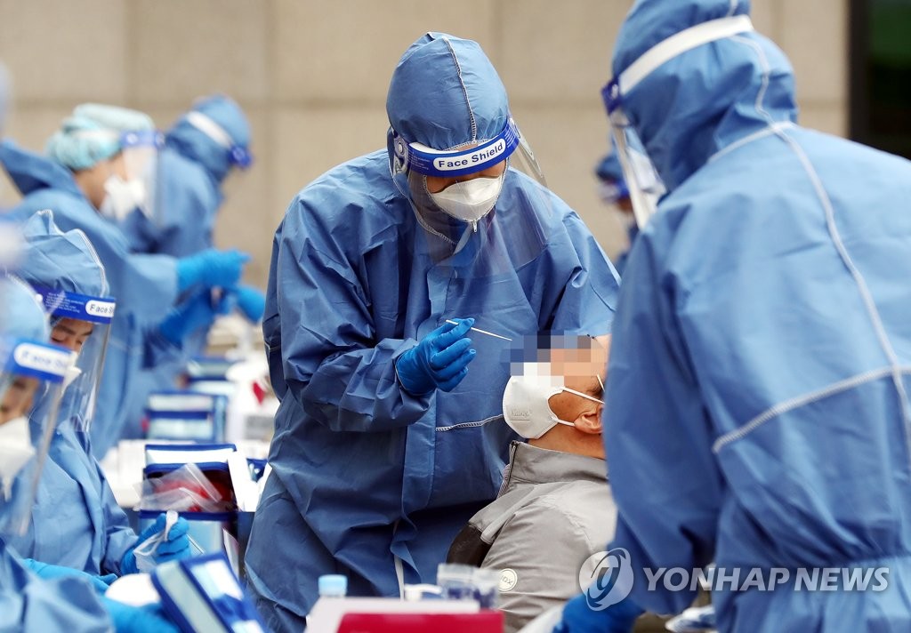 A group of medical workers collects samples from visitors to carry out new coronavirus tests at a makeshift clinic in Incheon, west of Seoul, on June 2, 2020. (Yonhap)