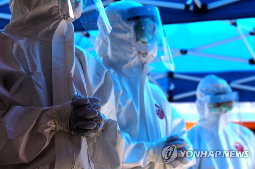 This June 5, 2020, photo shows health workers waiting to carry out virus checks of business owners and employees on a street in Euljiro, which is known for outdoors bars, in central Seoul. The test was conducted as part of precautionary measures to resume outdoor seating. (Yonhap)