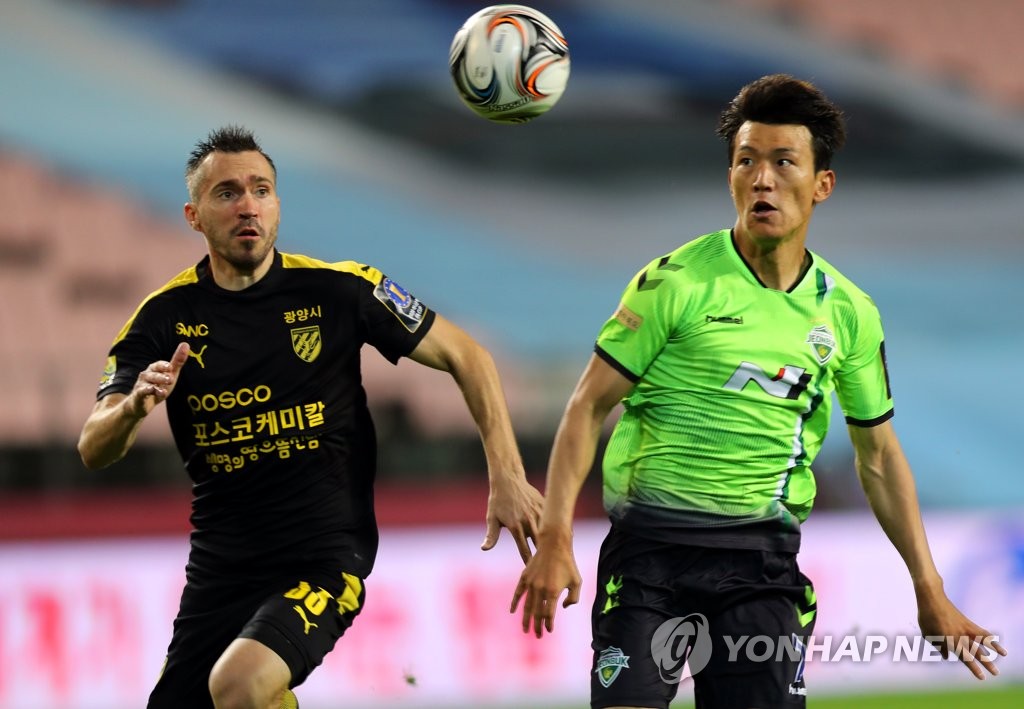 In this file photo from July 15, 2020, Oleg Zoteev of Jeonnam Dragons (L) and Han Kyo-won of Jeonbuk Hyundai Motors chase a loose ball during their round of 16 match of the FA Cup at Jeonju World Cup Stadium in Jeonju, 240 kilometers south of Seoul. (Yonhap)