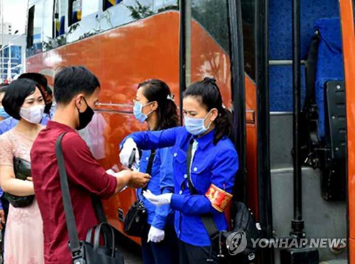 朝鮮労働党機関紙の労働新聞は、全国の鉄道の駅やバス停などで防疫を強化していると報じた。バスの乗客の体温を測定する様子（労働新聞ホームページより）＝（聯合ニュース）≪転載・転用禁止≫