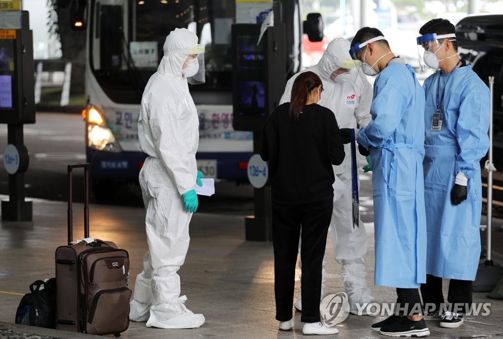 Quarantine officials inform an international arrival about transportation options at Incheon International Airport, South Korea's main gateway, west of Seoul, on July 27, 2020. (Yonhap)