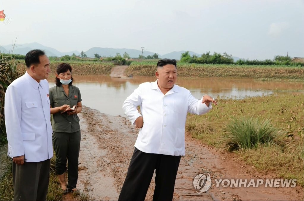 North Korean leader Kim Jong-un (C) speaks during a visit to a flood-ravaged village in Unpha, North Hwanghae Province, in this photo captured from the Korean Central Television Broadcasting Station on Aug. 7, 2020. The broadcaster did not say when he made the visit, but Kim is believed to have visited the village the previous day. (For Use Only in the Republic of Korea. No Redistribution) (Yonhap)