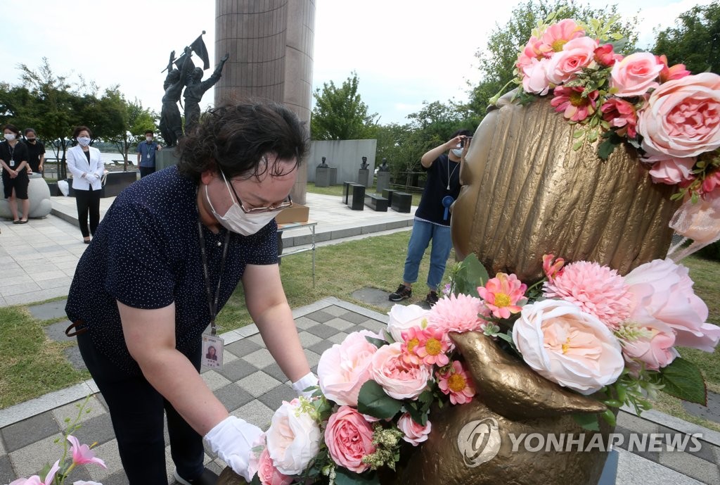 慰安婦被害者を象徴する「平和の少女像」が花で飾られている（資料写真）＝（聯合ニュース）