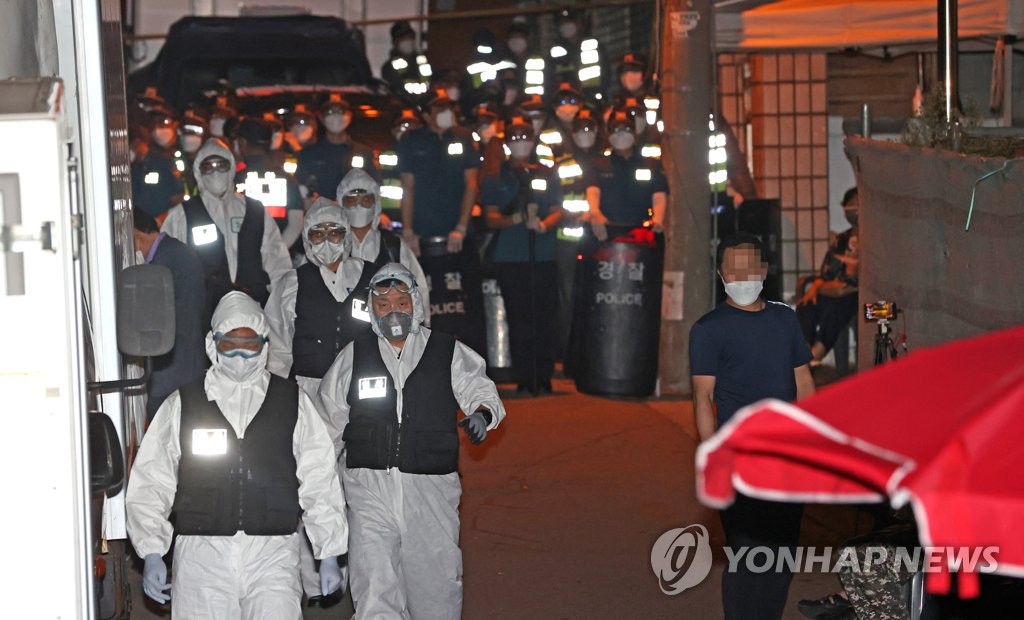 Wearing protective gear, police officers come out of the Sarang Jeil Church in northern Seoul on Aug. 20, 2020, while health authorities conducted an epidemiological study on more than 600 virus cases tied to the church. (Yonhap)