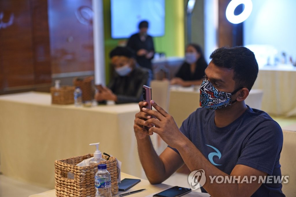 This photo provided by Samsung Electronics Co. on Aug. 21, 2020, shows an Indonesian reporter checking the company's Galaxy Note 20 smartphone at an event in Jakarta, Indonesia. (PHOTO NOT FOR SALE) (Yonhap)