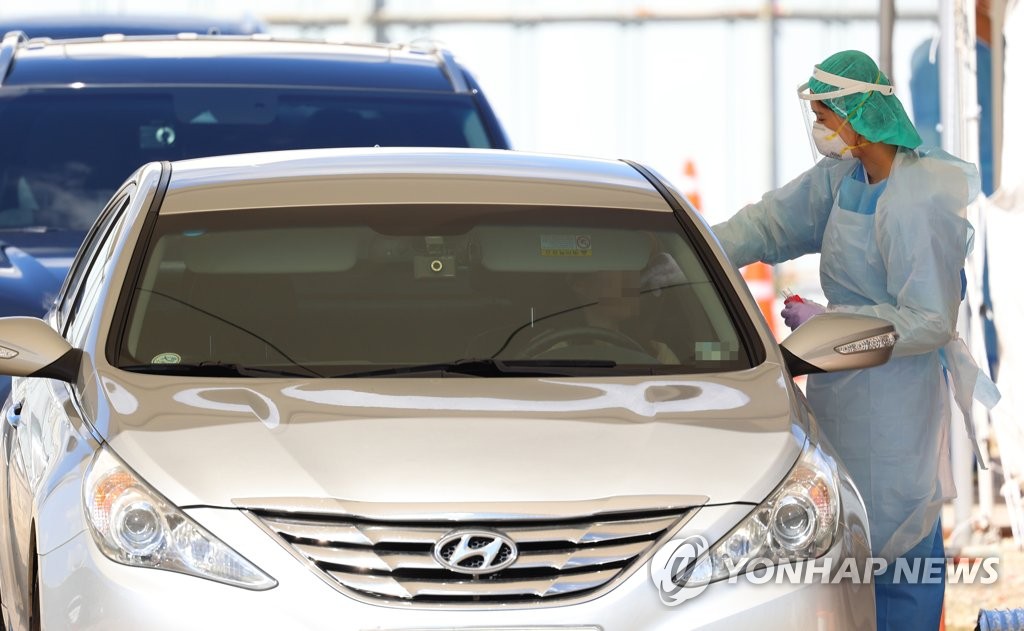 A medical worker carrys out new coronavirus tests at a drive-thru clinic in western Seoul on Sept. 4, 2020. (Yonhap)