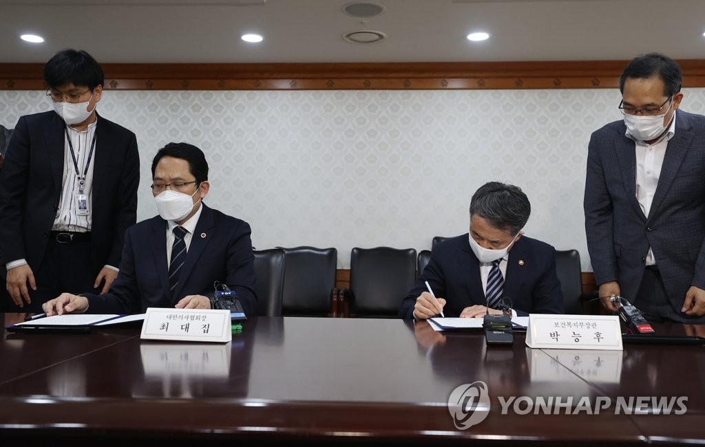 Health and Welfare Minister Park Neunghoo (R) and Korean Medical Association chief Choi Dae-zip sign an agreement calling for an end to the doctors' strike in Seoul on Sept. 4, 2020. (Yonhap)
