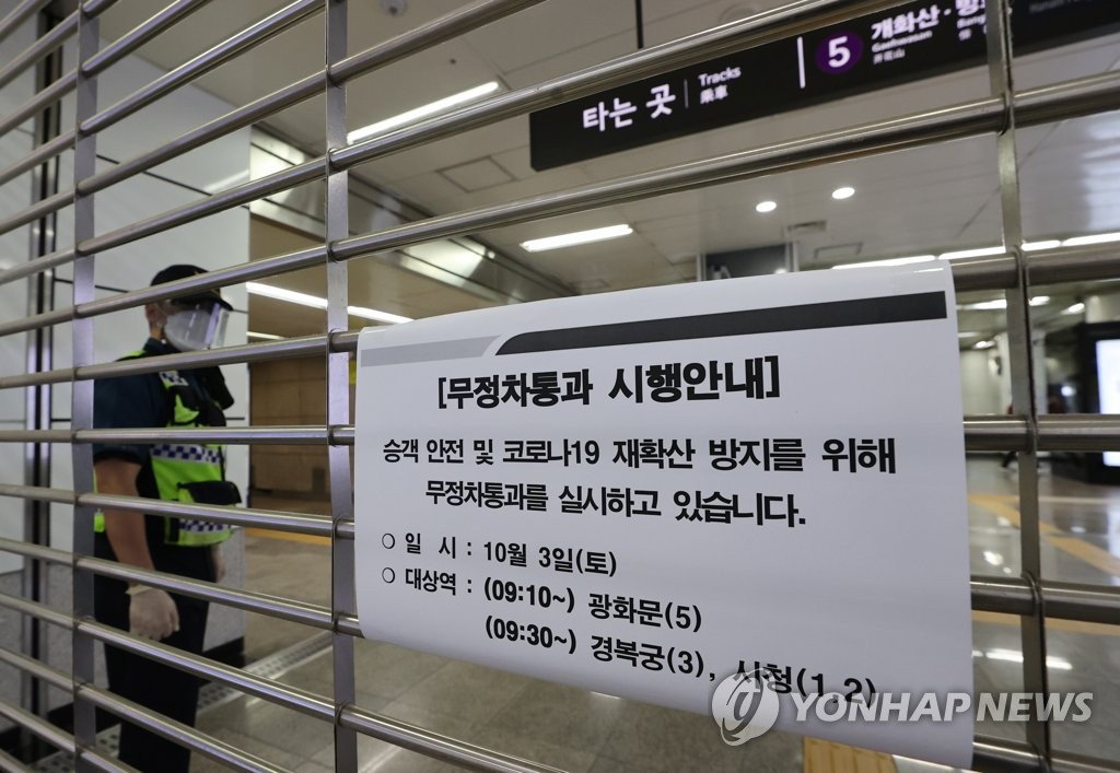 This photo, taken on Oct. 3, 2020, shows a gate closed at Gwanghwamun Station with a sign that says subways are not stopping to ensure passenger safety and contain the spread of COVID-19. (Yonhap)