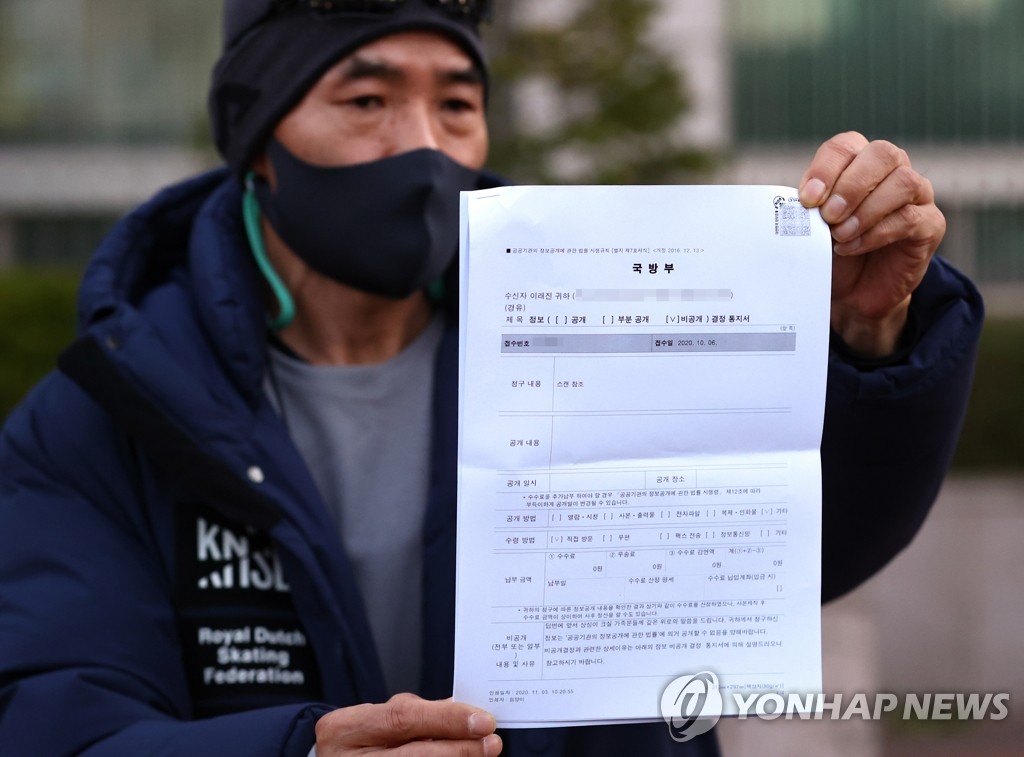 Lee Rae-jin, the elder brother of a South Korean official killed by North Korean soldiers while drifting in its waters in September, holds a document showing the government decision not to disclose military intelligence collected in the course of the incident after a meeting with defense ministry officials in Seoul on Nov. 3, 2020. (Yonhap)