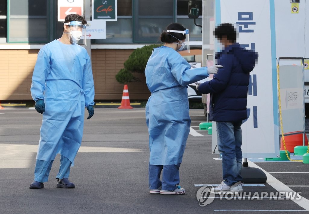 Des membres du personnel médical travaillent dans un centre de dépistage pour le nouveau coronavirus (Covid-19) installé au Centre médical national (NMC) à Séoul, le mardi 1er décembre 2020. 