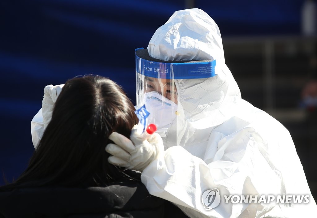 A medical worker carries out new coronavirus tests at a makeshift clinic in central Seoul on Dec. 14, 2020. (Yonhap)