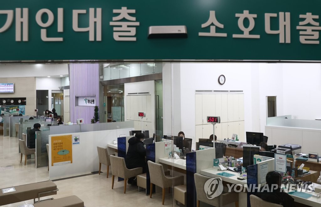 This file photo, taken Jan. 5, 2021, shows bank officials consulting with customers seeking to get loans at a lender in Seoul. (Yonhap)