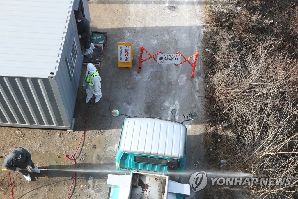 Officials carry out a disinfection operation at a poultry farm in Paju, 33 km north of Seoul, on Jan. 27, 2021. (Yonhap)