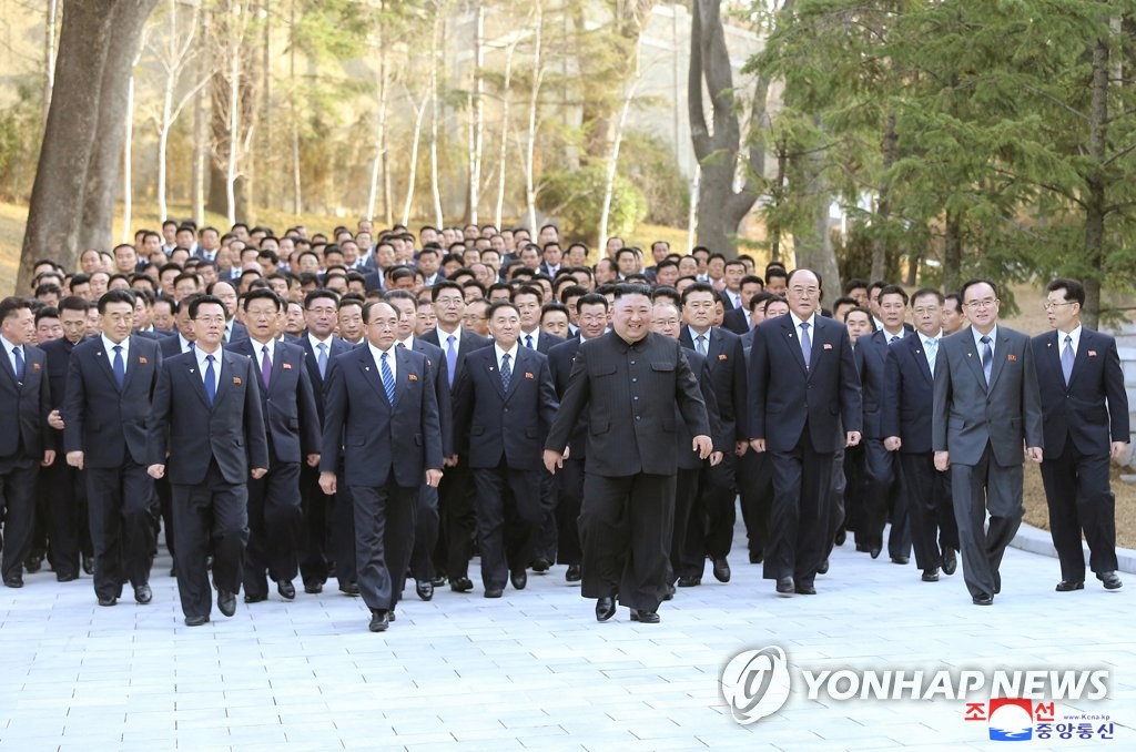 강습회 참가자들과 기념사진 촬영을 위해 이동하는 김정은